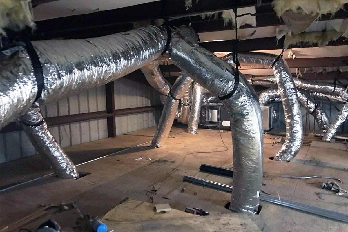 Insulated flexible ductwork running across an attic floor
